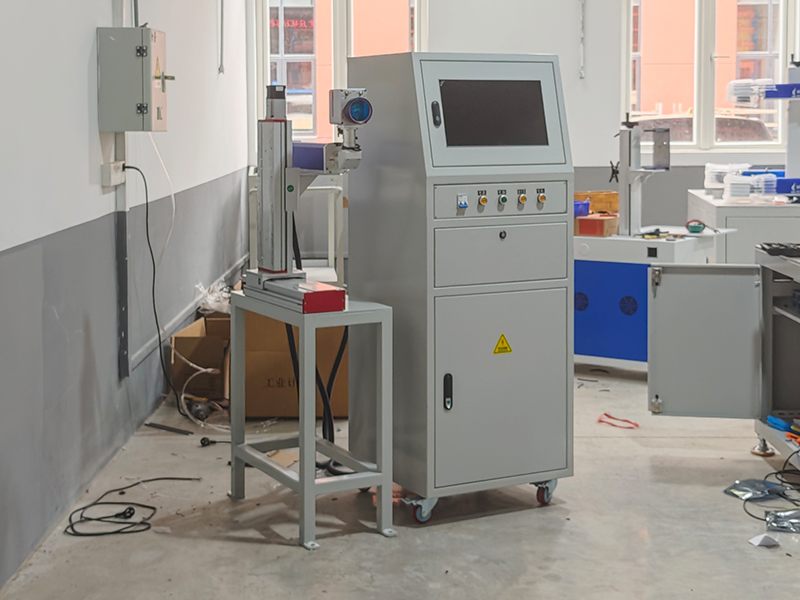 Close-up of automated laser marking on steel workpiece in production line