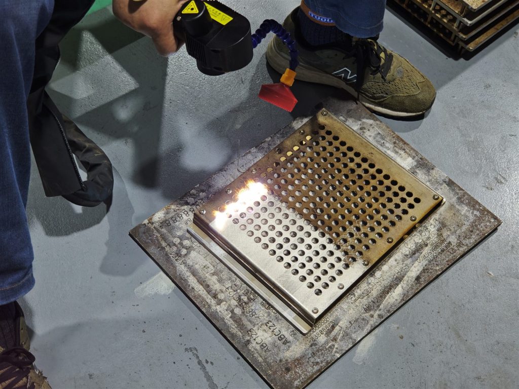 Customer operating the 300W pulsed laser cleaning machine during the on-site tray cleaning sample test