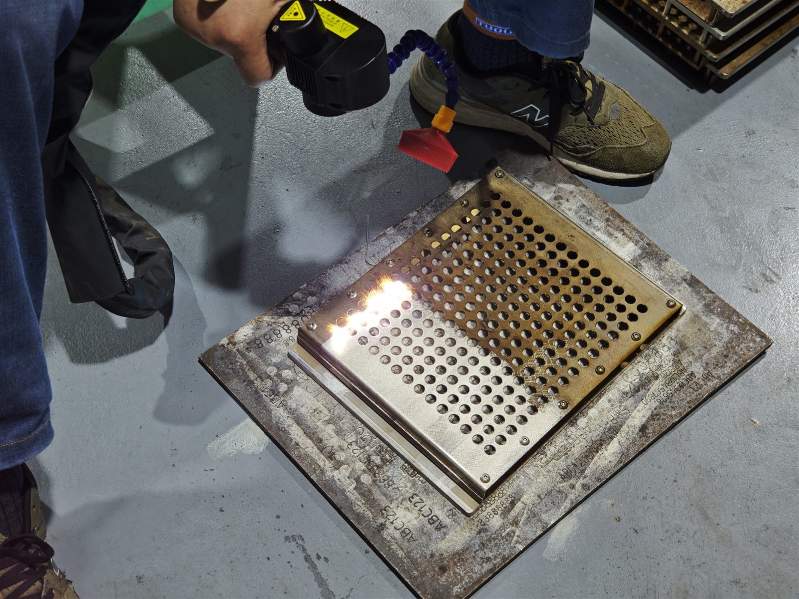 Customer operating the 300W pulsed laser cleaning machine during the on-site tray cleaning sample test